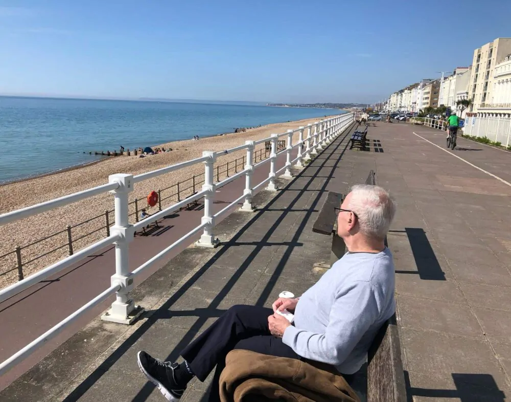 Man sitting on a bench looking at the sea