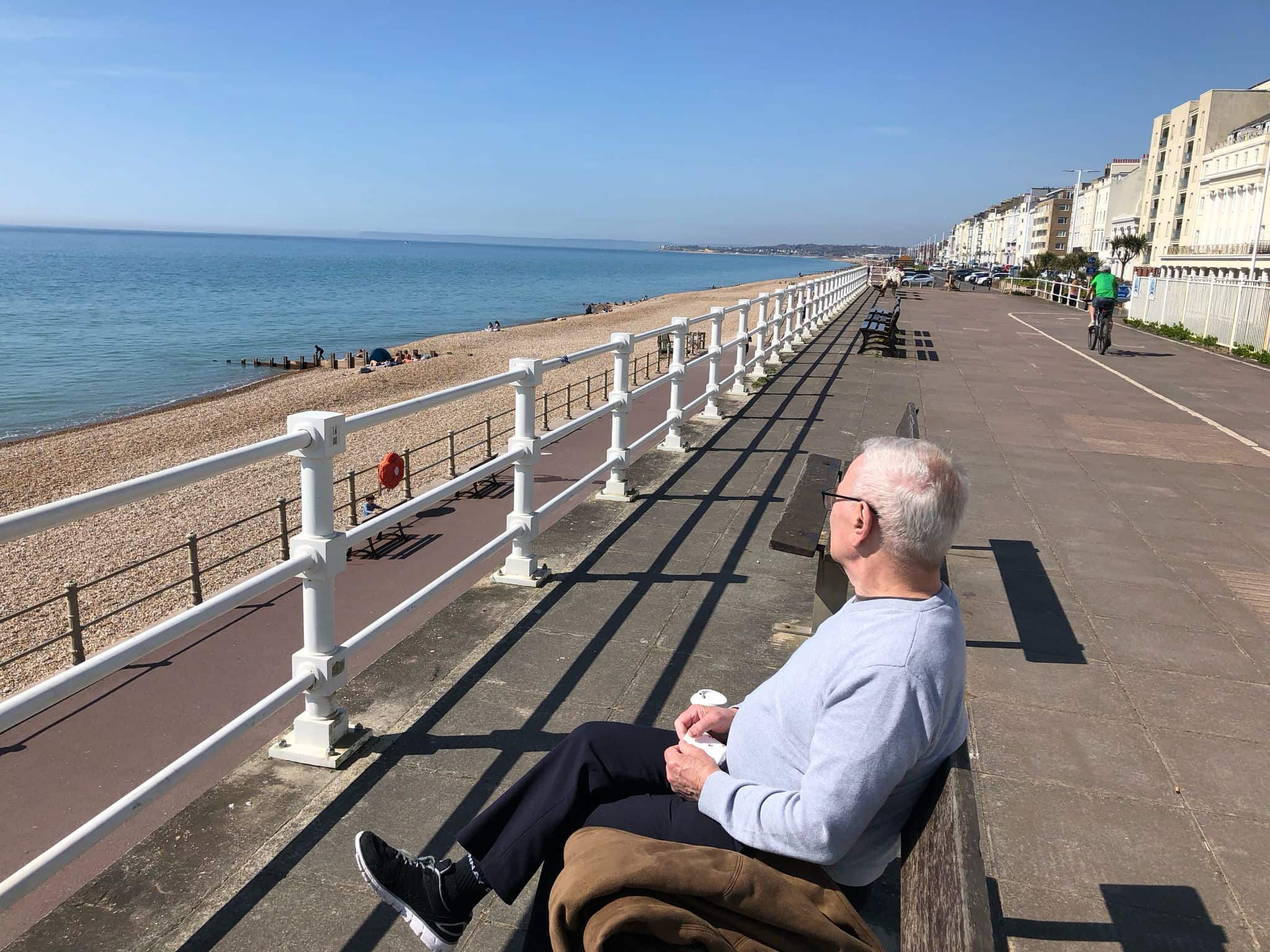 Man sitting on a bench looking at the sea