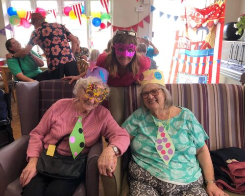 Residents wear masks for the Carnival themed summer party