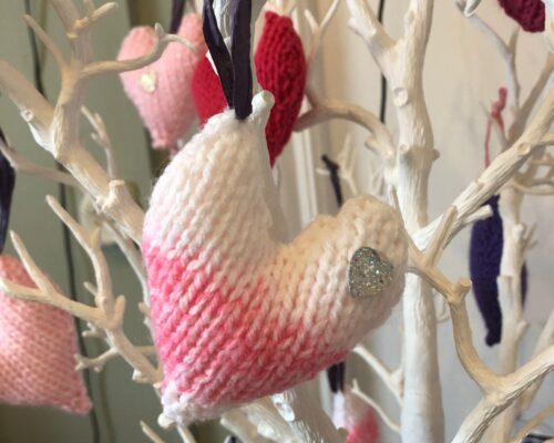 Knitted heart hanging on a branch.