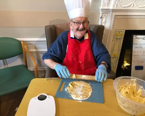 Resident rolling out pastry for baking