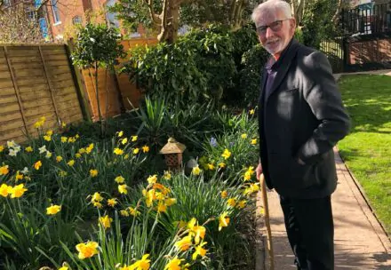 Resident standing in front of daffodils