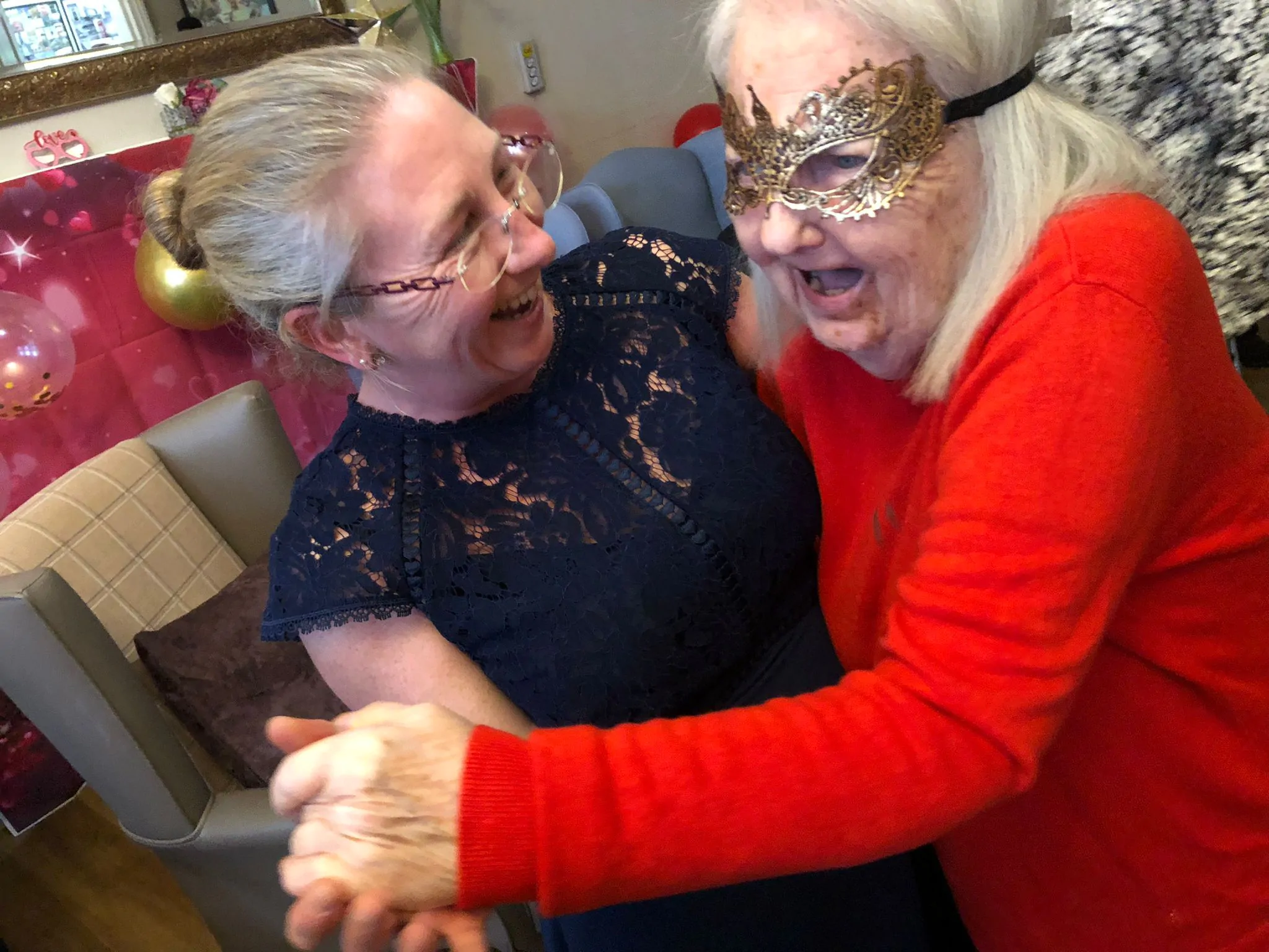 Two women hugging at the Valentine's Masked Ball