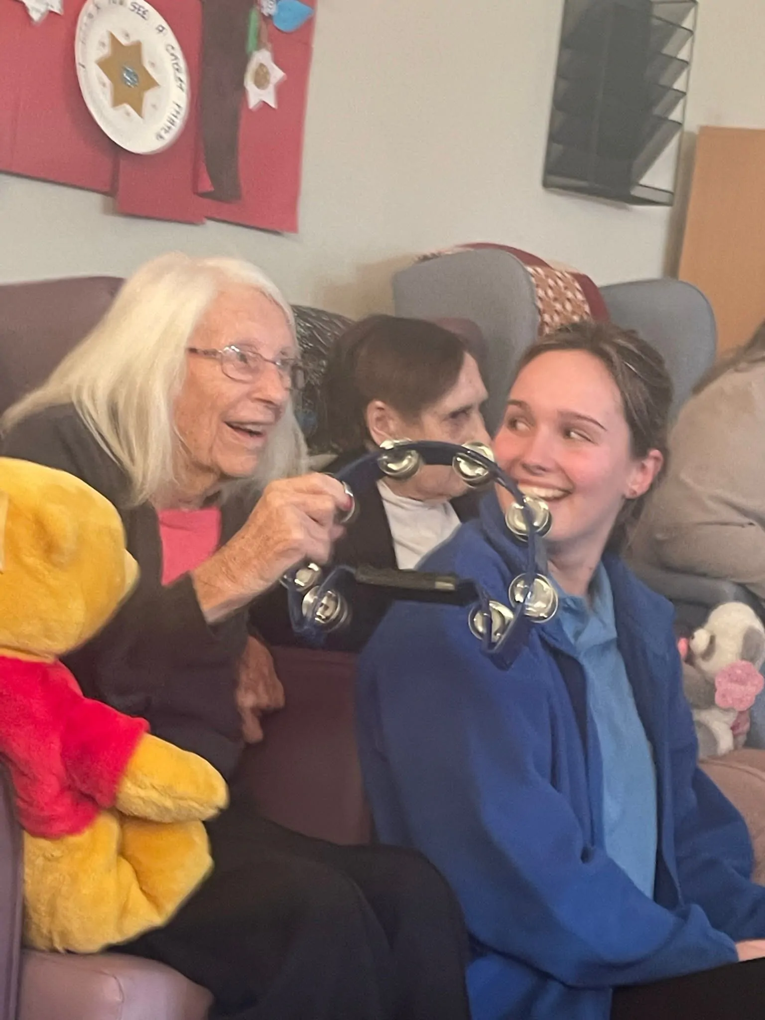 Resident shakes tambourine at Baby Glow event
